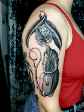 Large black and grey organic tattoo of a plant shaded with high contrast blacks and stippled dot work on the outside bicep