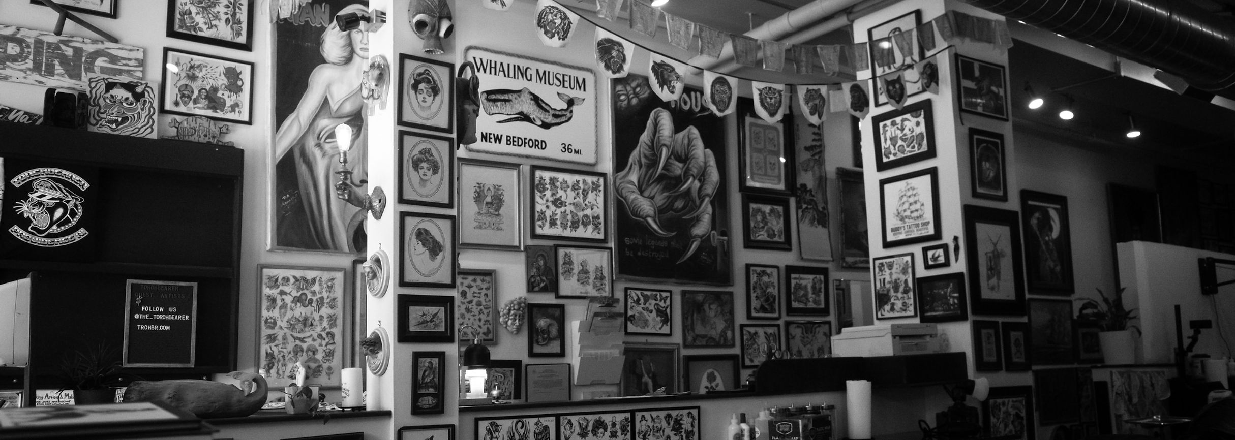 The lobby of Torchbearer Tattoo with walls filled with custom tattoo designs and flash.