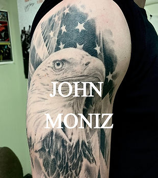 Photo realsitic black and grey eagle with American flag background on upper bicep.