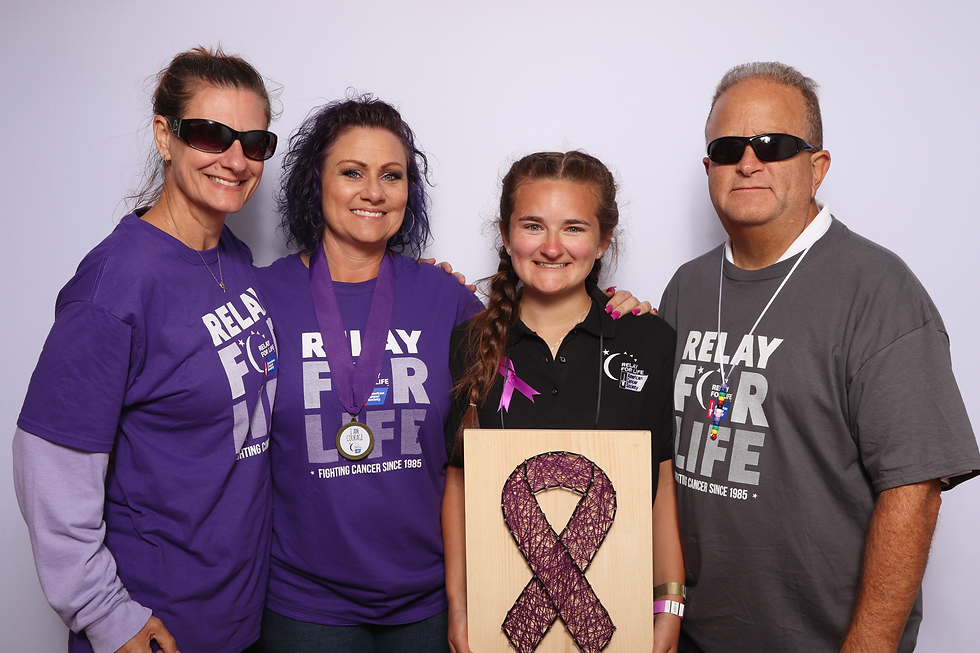 4 people from Relay for Life at Cal Poly posing with props