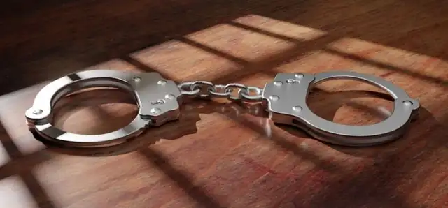 Open handcuffs on a wooden table