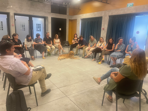 קבוצה יושבת במעגל עם כלב, מרכז חוסן