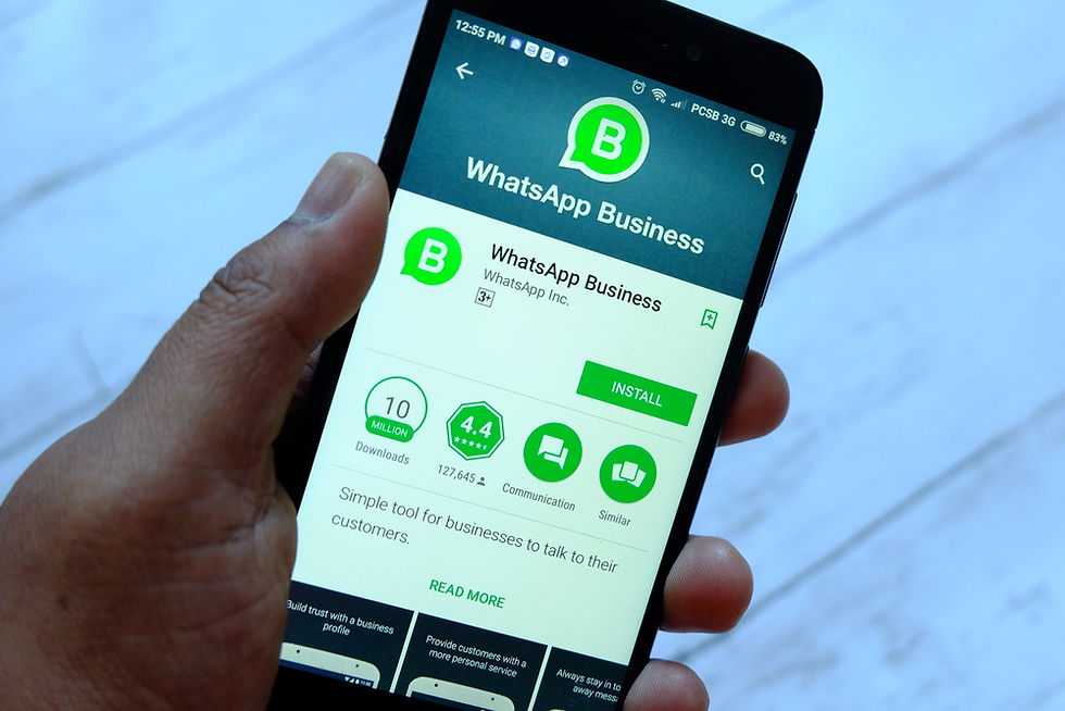 A person holding smartphone with Whatsapp Business app on an Android Google Play Store.