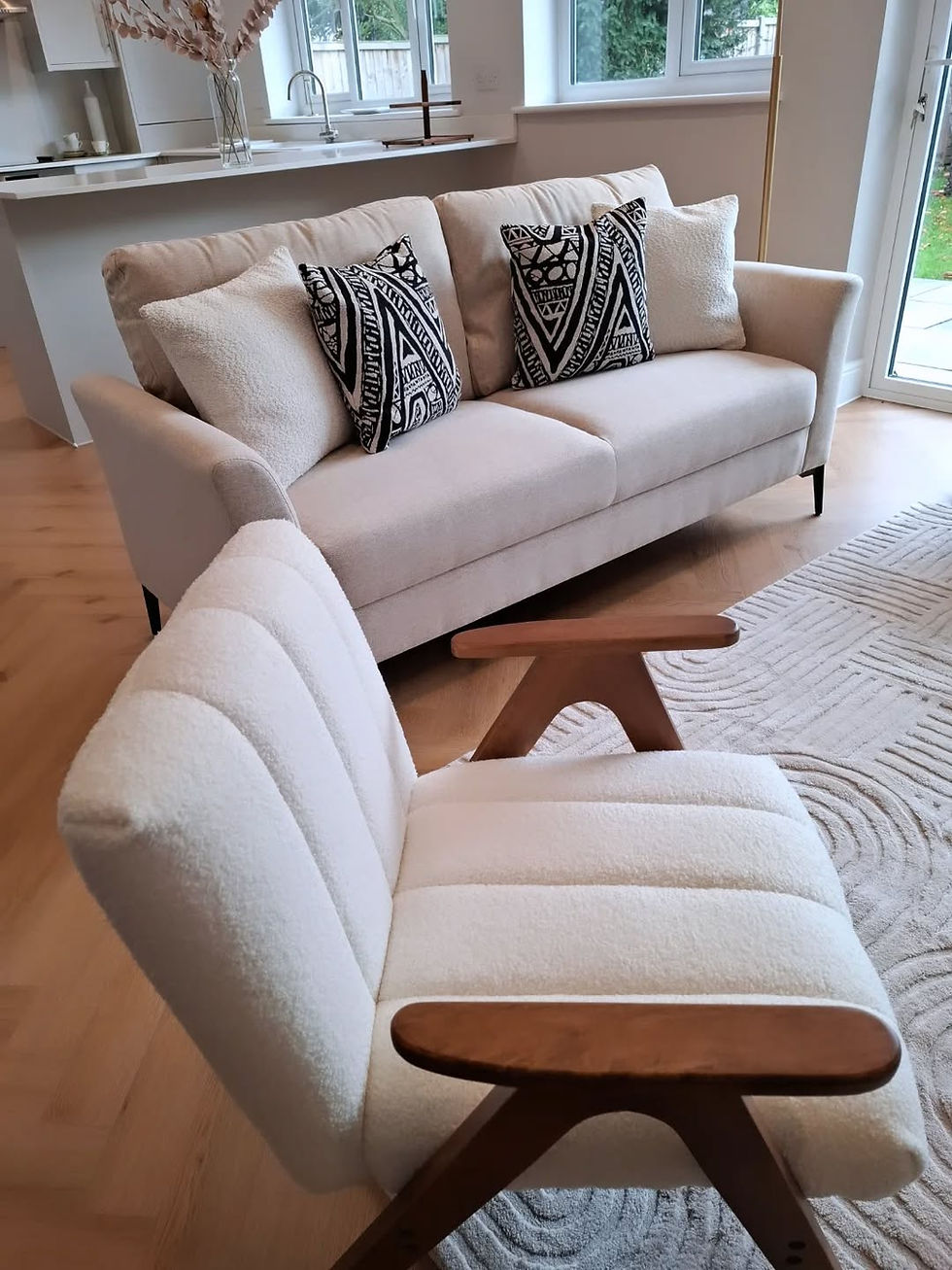 Close-up of neutral staged sofa and upholstered lounge chair with wooden arms
