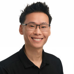 Professional headshot of a man wearing glasses and a black shirt, smiling against a light background