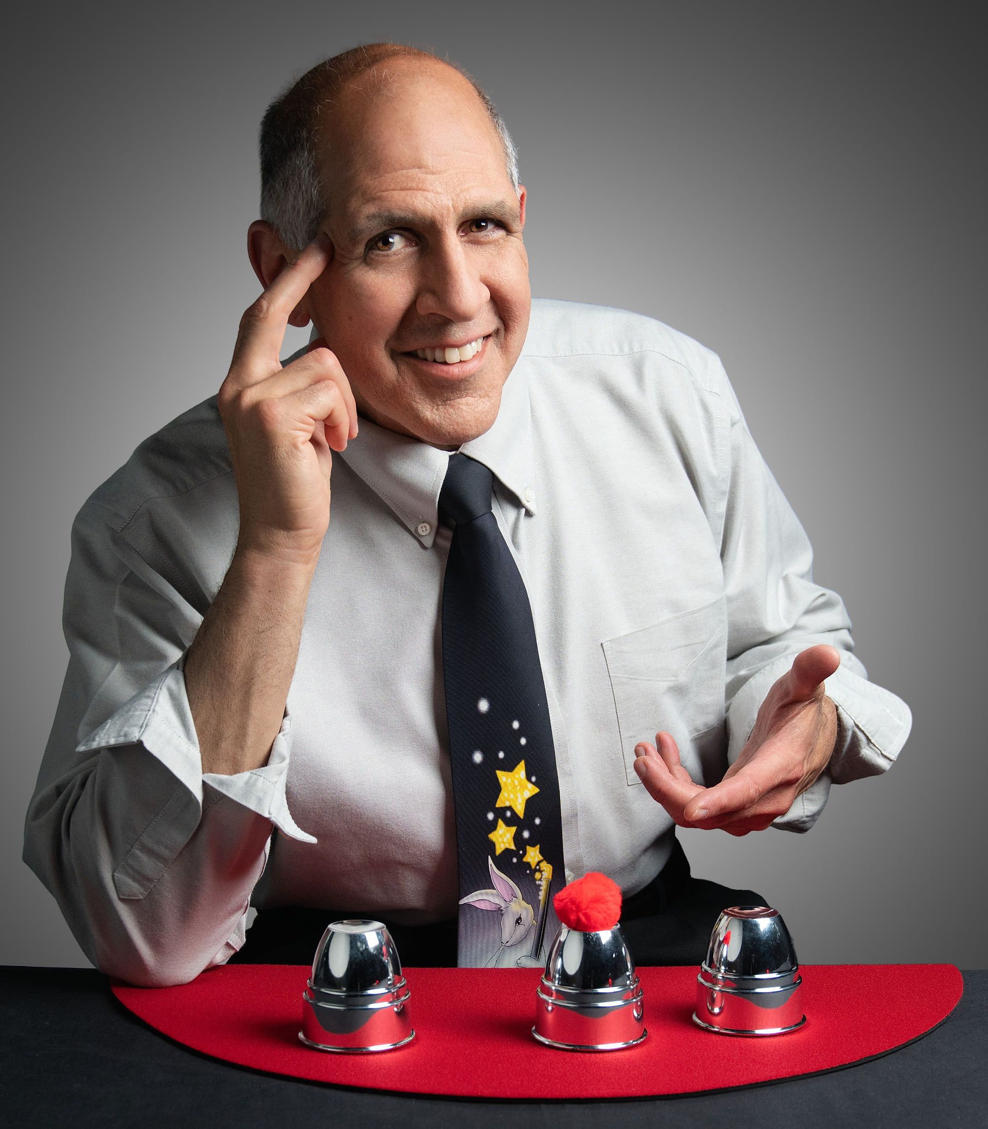 Branding portrait of magician performing cup and ball trick on table