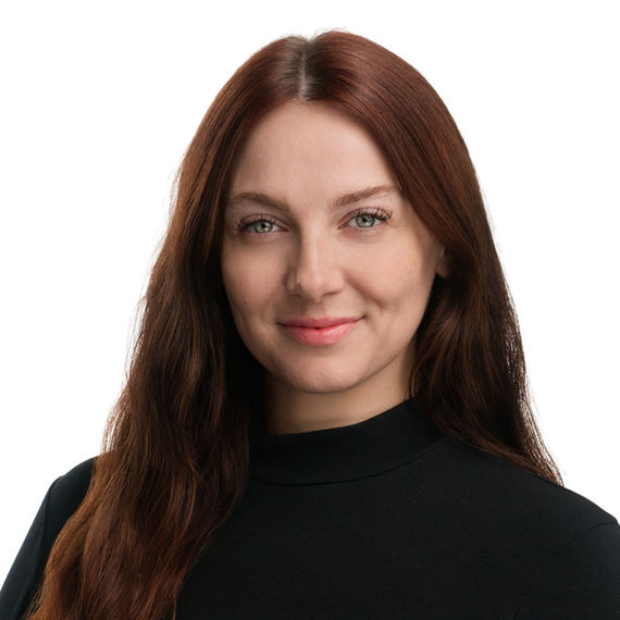 Professional headshot of a woman with long red hair wearing a black top.