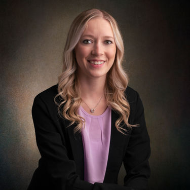 Corporate portrait of professional woman, dark textured backdrop