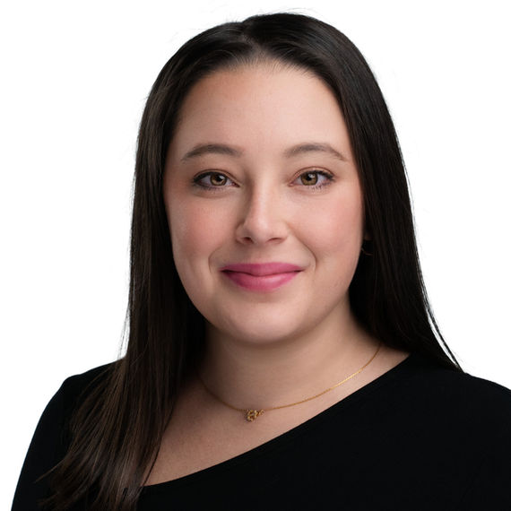 Professional headshot of a woman with long dark hair wearing a black top.