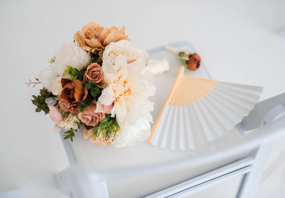 Elegant florals and hand-held fan on a chair during elopement ceremony