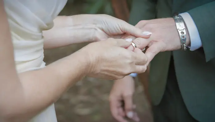 Close-up of a bride placing a wedding ring on the groom’s finger during an Atherton Tablelands wedding ceremony