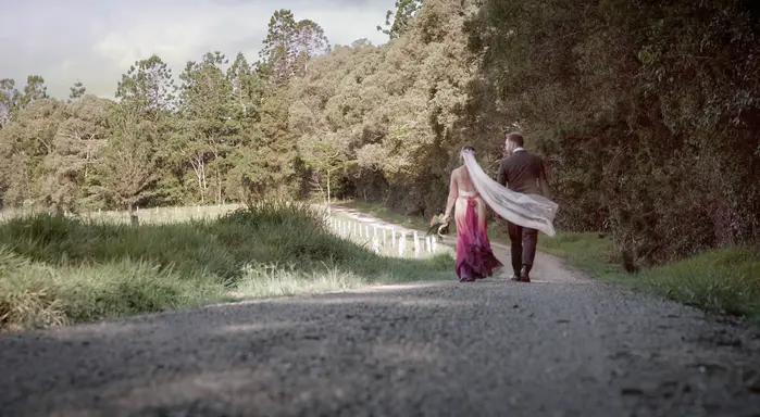Bride and groom walking together through a rural wedding location in the Atherton Tablelands