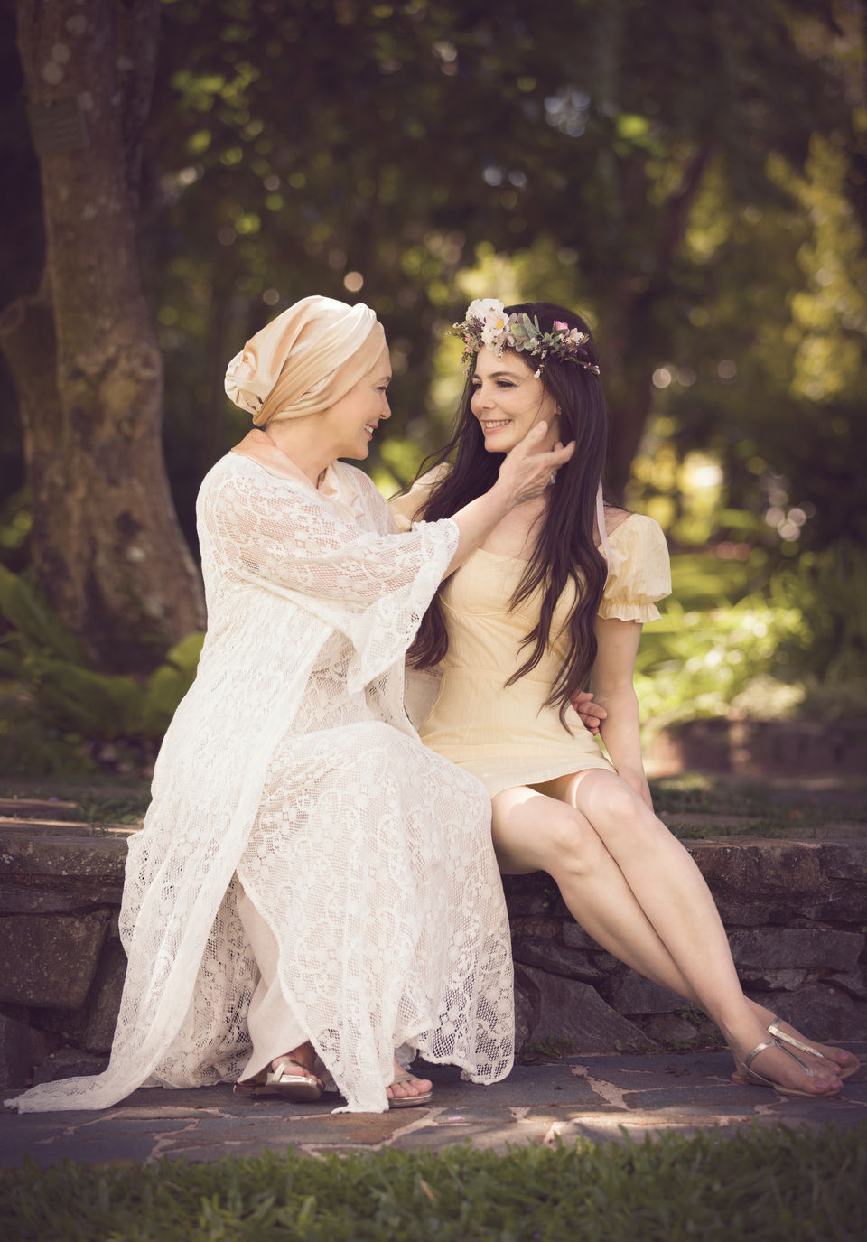 Family Portrait of mother and her daughter dressed in white and yellow outfits smiling to each other and posing in the tropical garden. Family Photographer in Cairns. Shamrock Space Studio