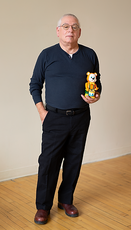 A photo of Arnold Faber standing with a vintage toy bear.