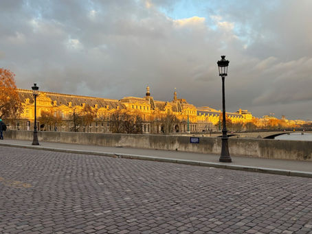 Golden hour in Paris, the Louvre seen from a cobblestoned bridge