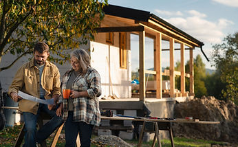 Mature couple having coffee break when working together on construction site of their new