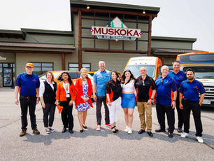 A group of people on the tarmac in front of the Muskoka Air Terminal.
