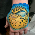 Yellow new school pufferfish tattoo on the hand in a bold illustrative style by Joe Swider in Connecticut