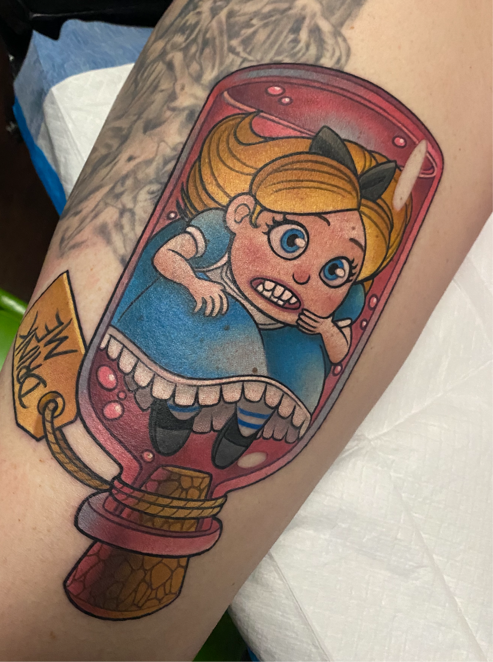 Color new school tattoo of Alice in Wonderland inside a pink jar with a Drink Me tag in surreal illustrative style