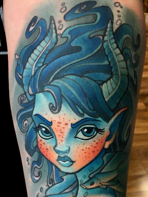 New school Capricorn zodiac tattoo by Joe Swider featuring a horned woman underwater with fish swimming around her in a vibrant illustrative design.