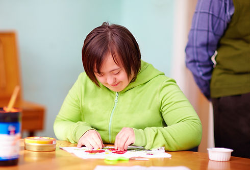 young adult woman with disability engaged in craftsmanship in rehabilitation center.jpg