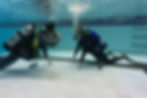 Scuba instructor demonstrating skill to a child in the pool.