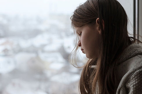 Sad Depressed Teen Girl sitting Alone and Depressed on the windowsill. Unhappy teenager is