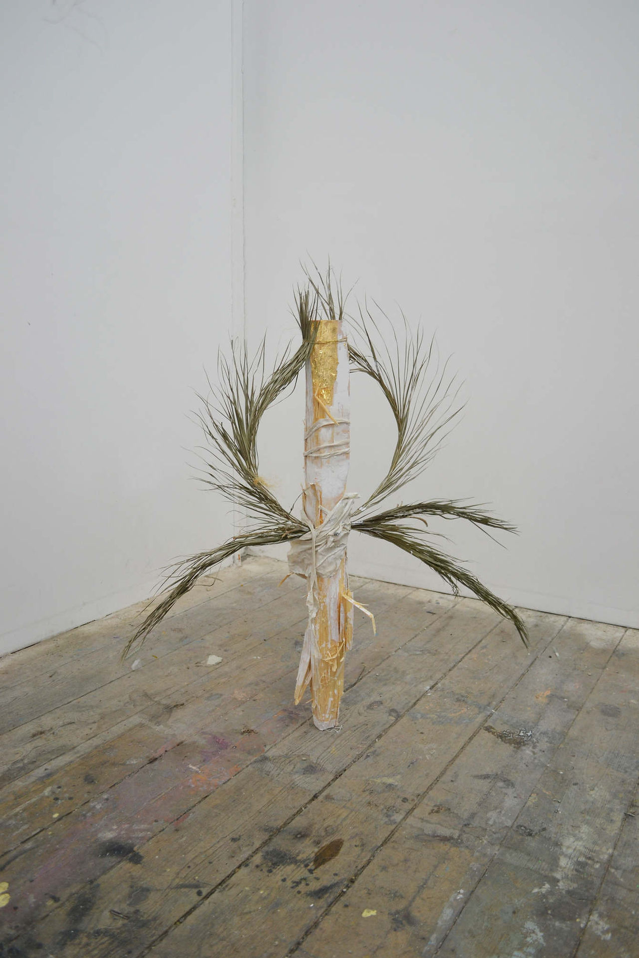 A contemporary sculpture using found art materials, including feathers and wood by a contemporary British artist.
