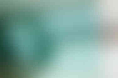 A curved, textured glass wall with a rippled, water-like effect, casting soft light and shadows.