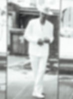 A black and white photo of Sean Jones, wearing a white outfit and white hat