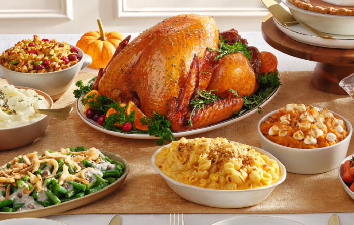 Thanksgiving dinner on a table showing turkey, casserole, macaroni and cheese