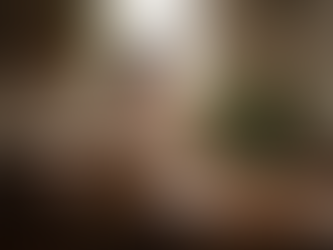 Woman sitting at a kitchen table with a notebook and tea, looking thoughtful after a difficult conversation.