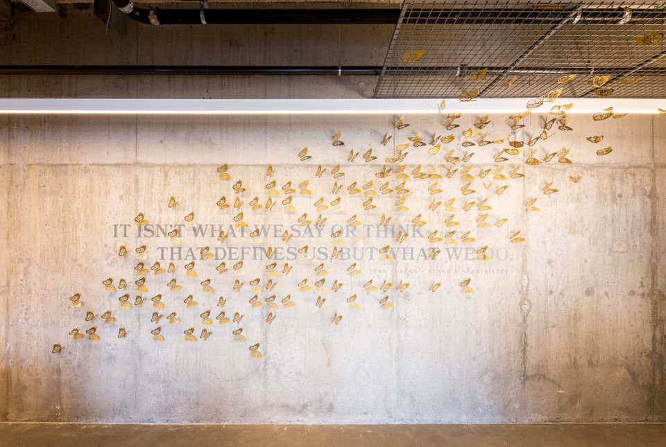 Wall graphic detail of three dimensional gold butterflies.