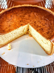 Käsekuchen serviert auf einem weißen Teller mit einem Stück entfernt. Köstlich aussehend.