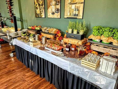 Buffet with various foods on display Restaurant setting with green wall and paintings