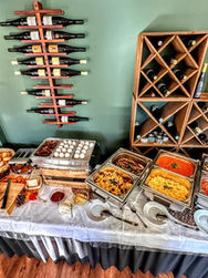 Buffet mit Speisen und Weinflaschen im Hintergrund, Speisekarte, Palais M.Oguz.
