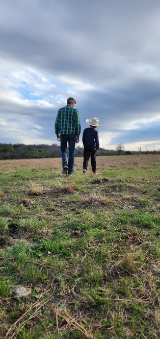 dad and son walking in field