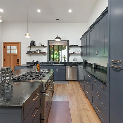 Contemporary kitchen renovation in Hamilton featuring custom dark cabinetry, premium black countertops, and a professional-grade gas range.