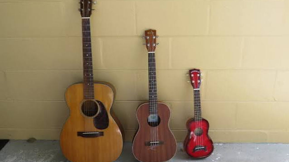 Left to right: A guitar, a baritone ukulele, and a soprano ukulele