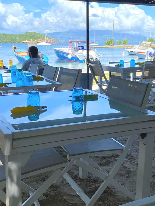Lunch at a table with your feet in the sand, with a sea view of the Saintes Islands in the background.