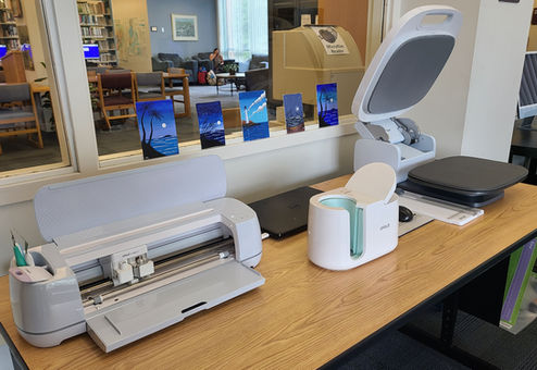 Cricut Maker 3, Mug Press, and Autopress on a table in the Innovation Lab.
