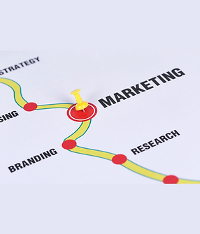 Close-up of a roadmap diagram with a yellow pushpin marking “MARKETING,” alongside stages labeled branding and research.