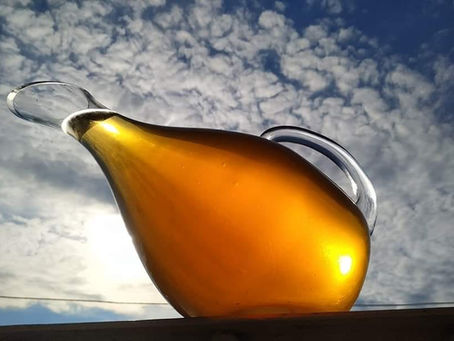 Golden amber wine in a traditional Georgian pitcher against a clear sky — Rkatsiteli Qvevri from Qvevri Wine Georgia