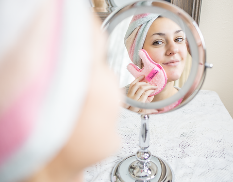 CocoBabbit pink pad being held by a lady whilst looking in the mirror