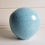 Thumbnail: Handgemaakte bol urn in een matte lichtblauwe kleur. Geschikt voor een gedeelte van de as.