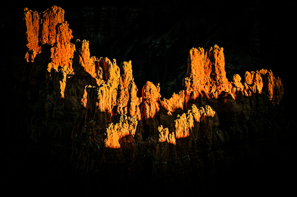 the sun shines through the rocks on a dark night