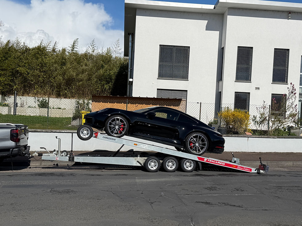 Zwarte Porsche 911 Carrera 4S 2025 op transportwagen, ingevoerd vanuit Duitsland via SoHo Automotive