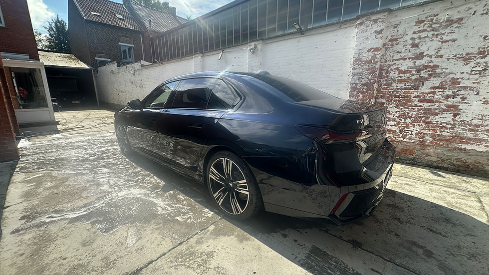 Zwarte BMW i7 xDrive60 achterkant detail, toont elegante lijnen en moderne design, rode bakstenen gebouw op achtergrond