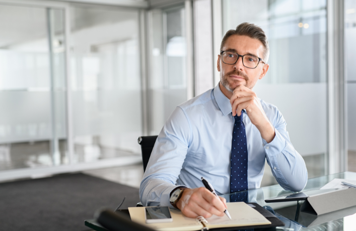Business professional in an office, thoughtfully evaluating a business for purchase