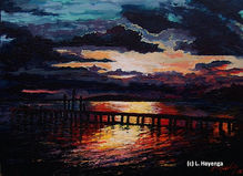 Cloudy twilight skies reflect brilliant colors of orange and yellow off the waters of a bayou.